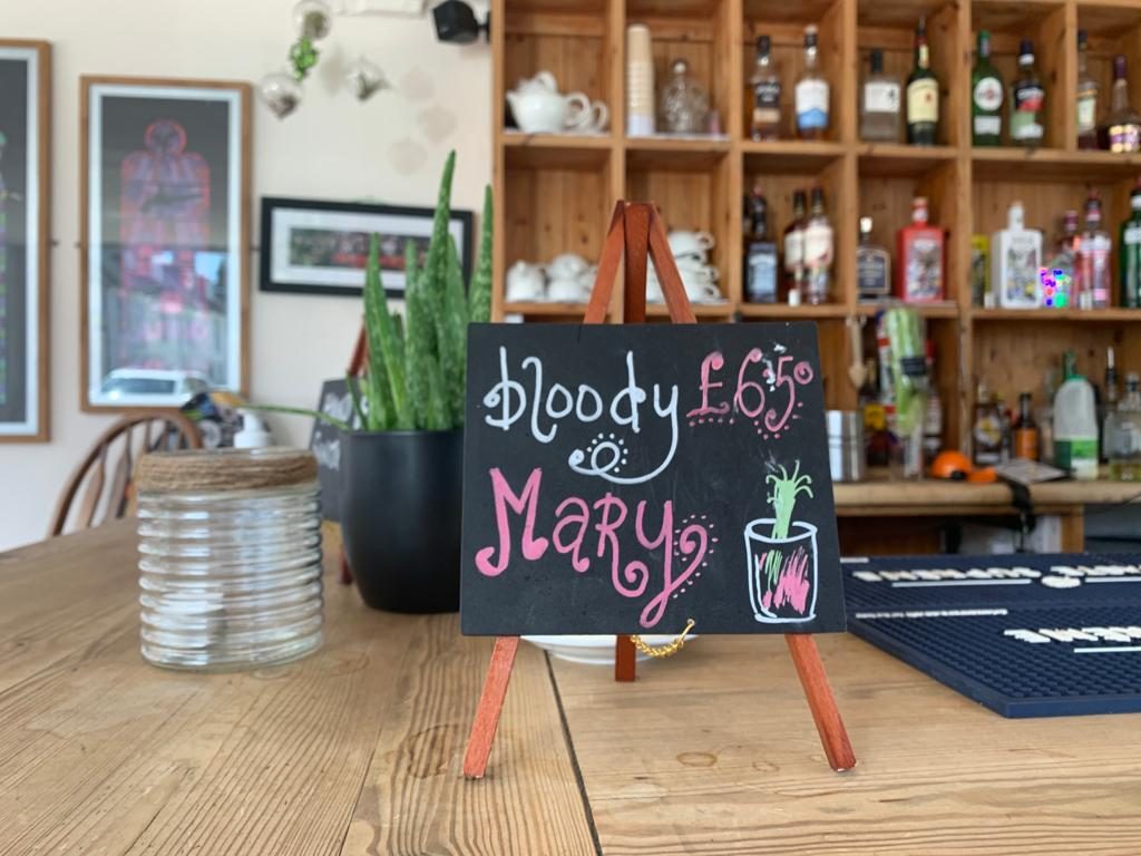 A Bloody Mary chalkboard sign by the bar shelves