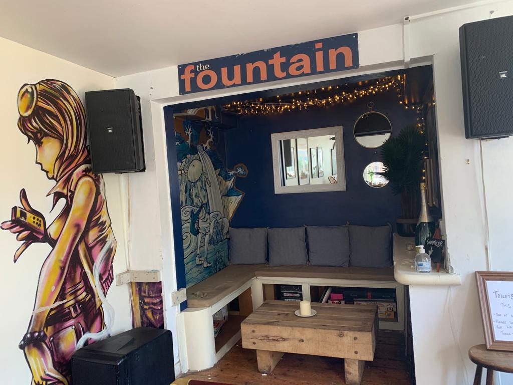 A snug with a painted mural and a Fountain sign