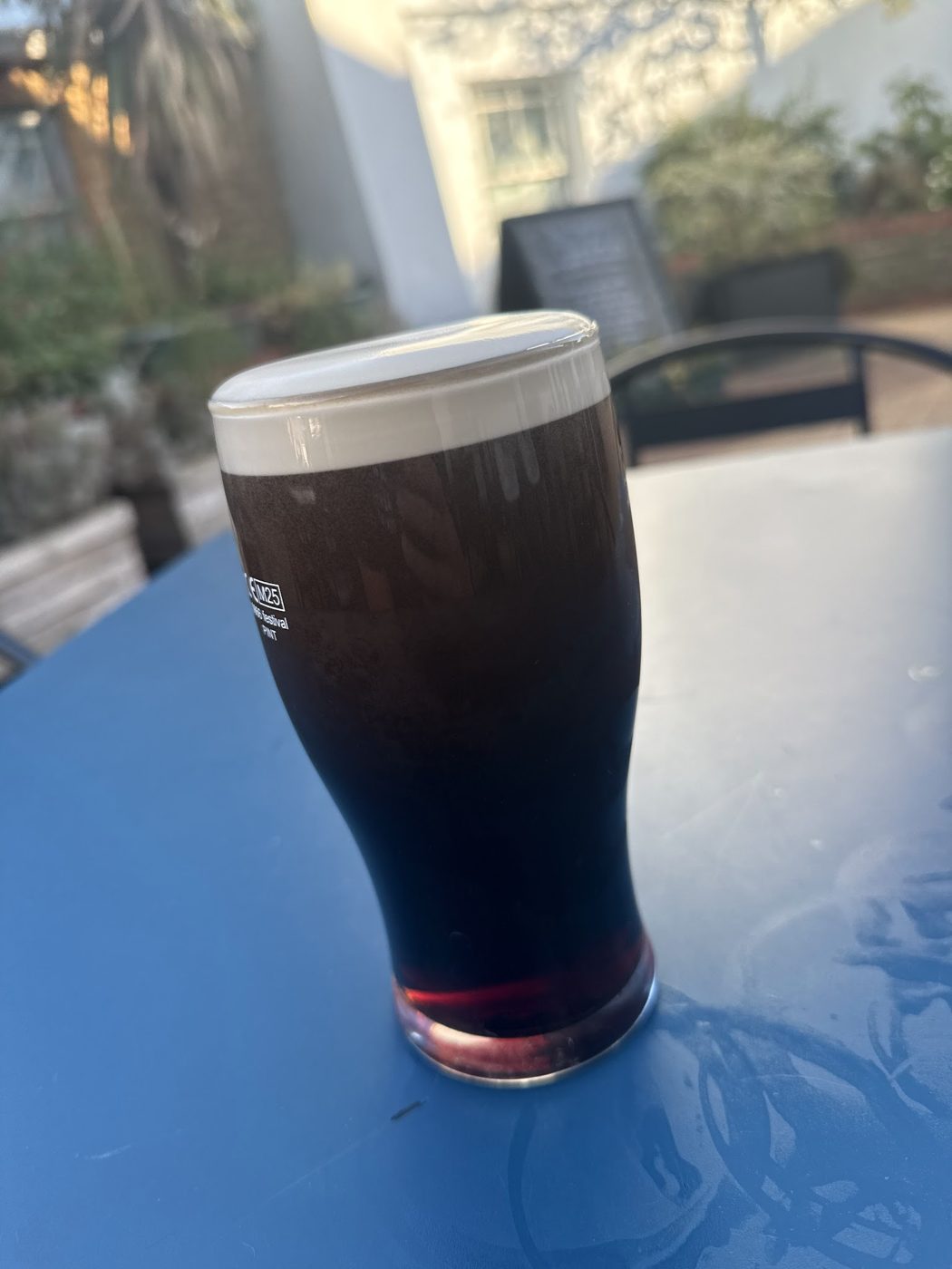 A pint of stout on a blue table